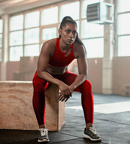 "Woman athlete sitting down after workout"